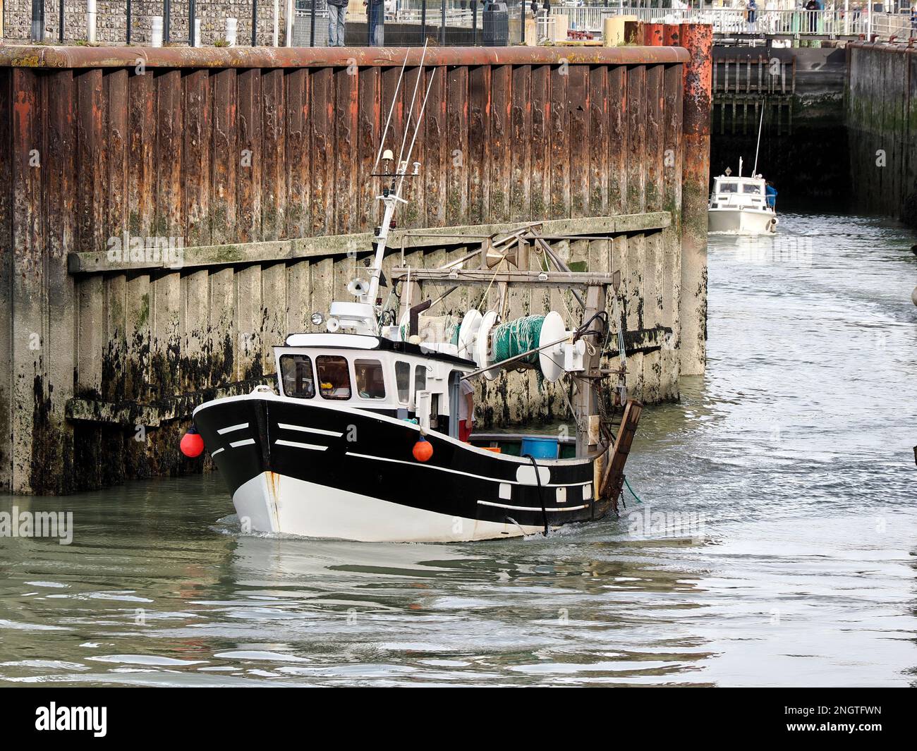 Fischerboot, das eine Schleuse in Le Treport, einer Gemeinde im Departement seine-Maritime in der Normandie im Nordwesten Frankreichs, verlässt. Stockfoto