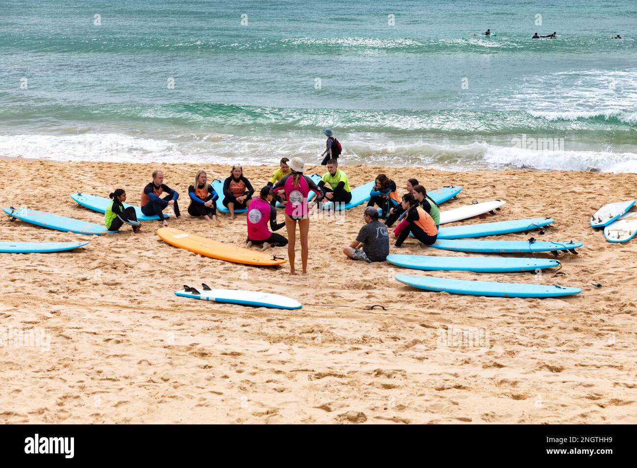 Gruppe von Personen, die im Sommer 2023 Surfunterricht am Manly Beach in Sydney, Australien, haben Stockfoto