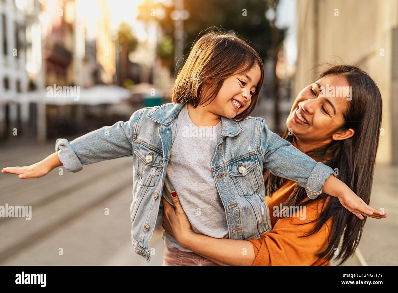 Glückliche Filipina Mutter mit ihrer Tochter, die Spaß im Stadtzentrum hat - nette Familie draußen Stockfoto
