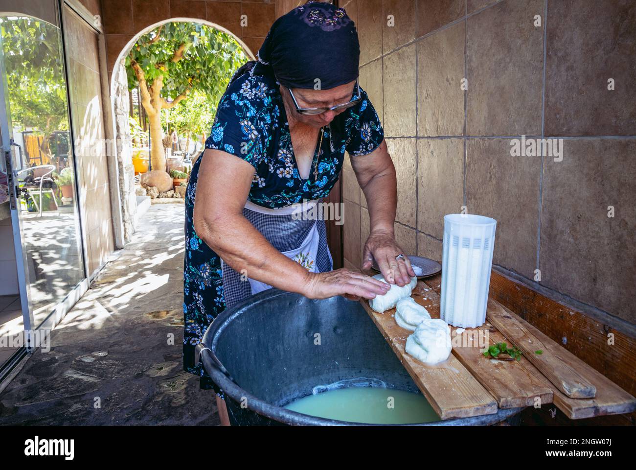 Frau Sofia macht Halloumi-Käse in Sofia und Andreas traditionelles Haus im Dorf Letymbou im Paphos-Bezirk der Insel Zypern Stockfoto