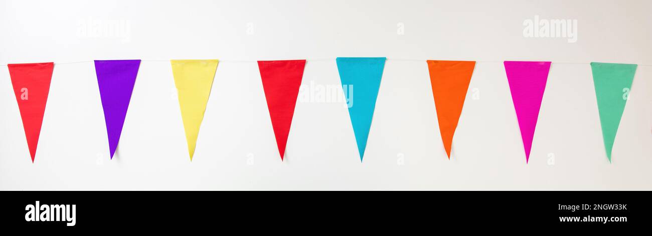 Karnevalsparty, Girlande, farbenfrohe Dreiecksfahne, die an einer Schnur auf weißem Hintergrund hängt. Festliche Dekoration, Einladungskarte, Festveranstaltung. Banner. Stockfoto