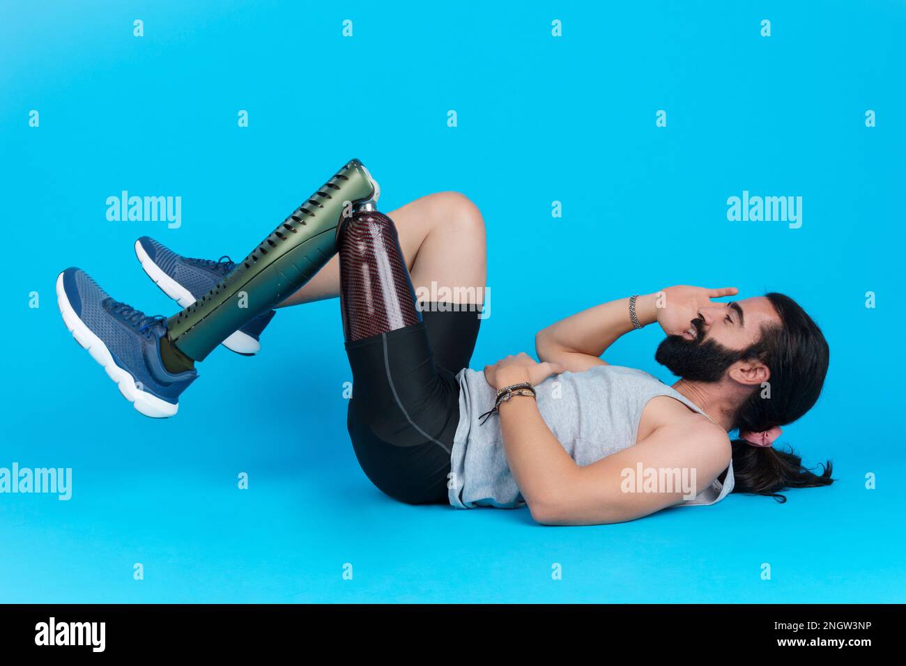 Mann mit Beinprothese, der Sit-ups macht Stockfoto