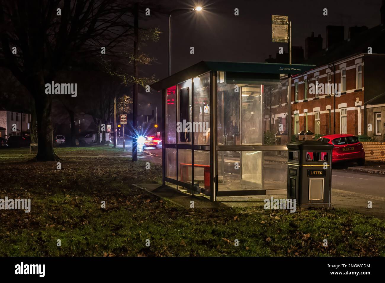 Bushaltestelle in einer Vorstadtstraße in Cardiff bei Nacht. Stockfoto