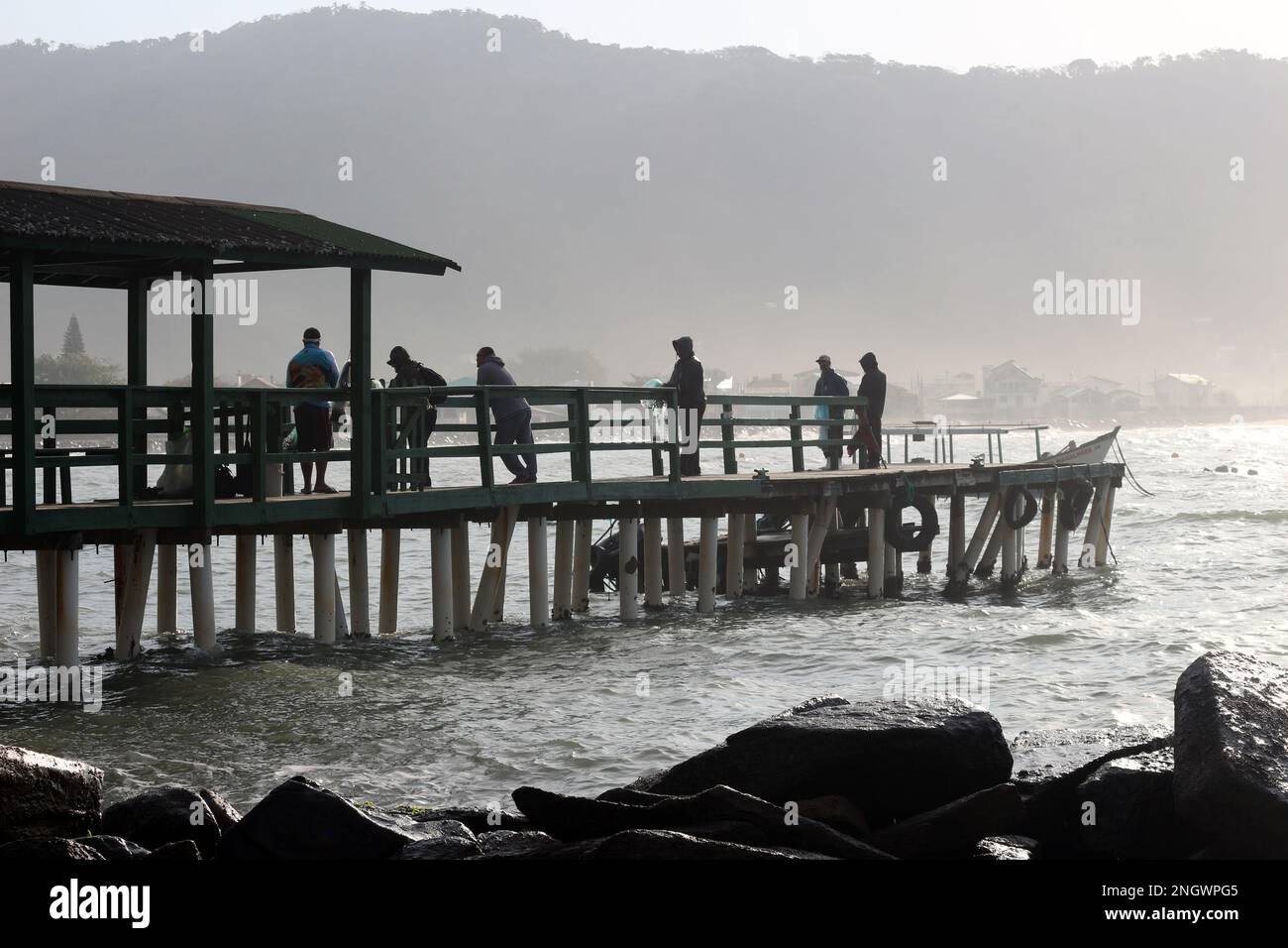 In der Dämmerung warten die Fischer am Pier auf die richtige Zeit, um das Netz zu werfen. Stockfoto