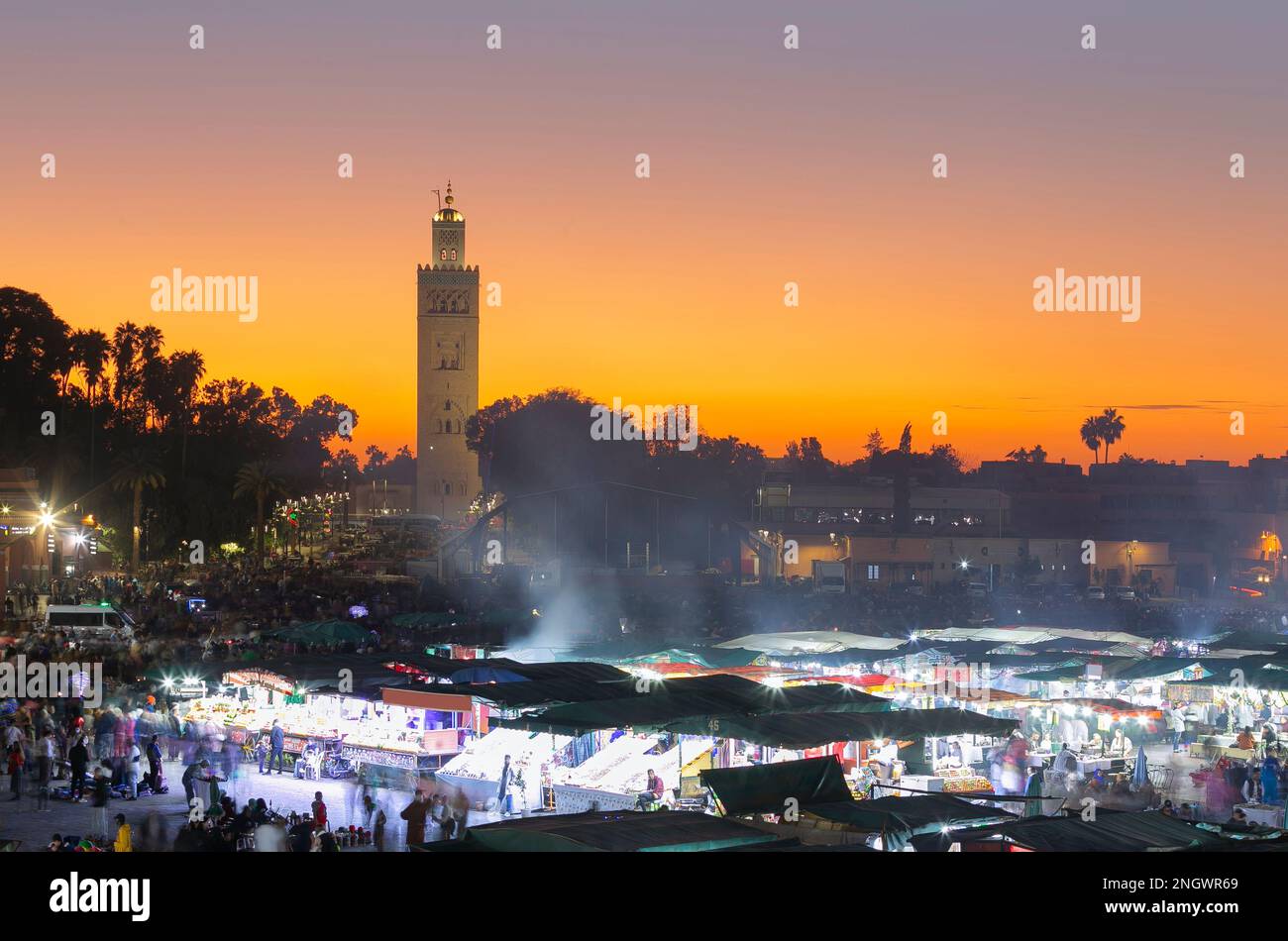 jemaa el Fna bei Sonnenuntergang. Die Nacht naht und das Stadtleben beginnt auf dem Markt. Stockfoto