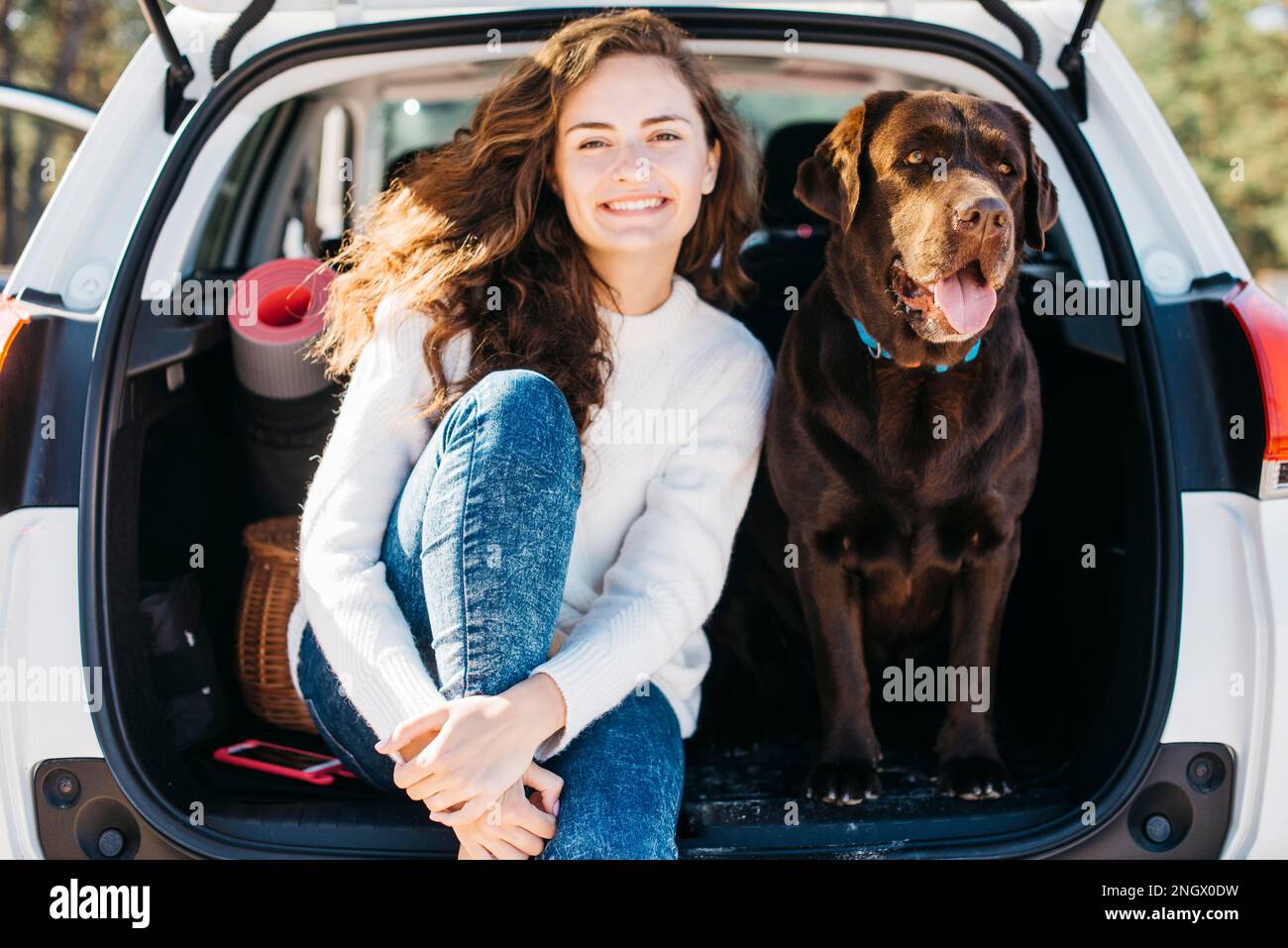Frau sitzt mit ihrem Hund offenen Kofferraum Stockfoto