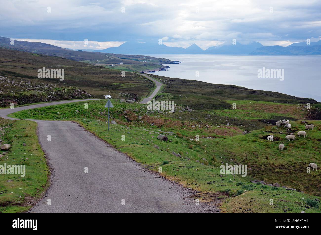 Schmale, einspurige Straße, schlängelt sich durch weite, grüne Landschaften entlang des Meeres. Applecross, Highlands, Schottland, Großbritannien Stockfoto