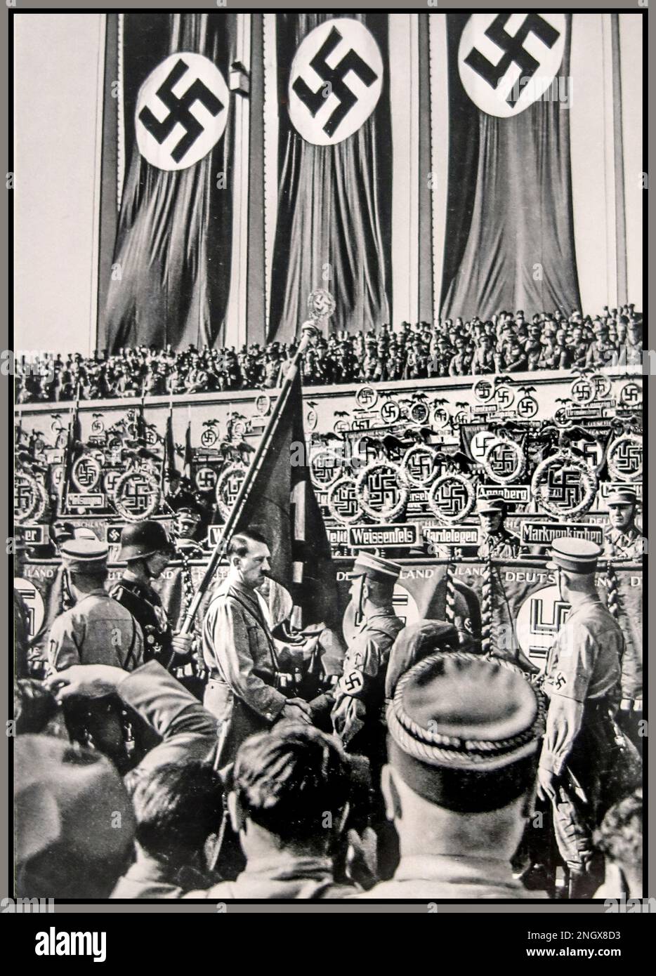 1934 Nazideutschland-Propaganda Nürnberg-Rallye mit dem Titel „die Einhaltung der Standards“. Adolf Hitler in SA Sturmabtleitung Uniform mit großem Swastika-Banner im Hintergrund Nürnberger Nazideutschland Stockfoto