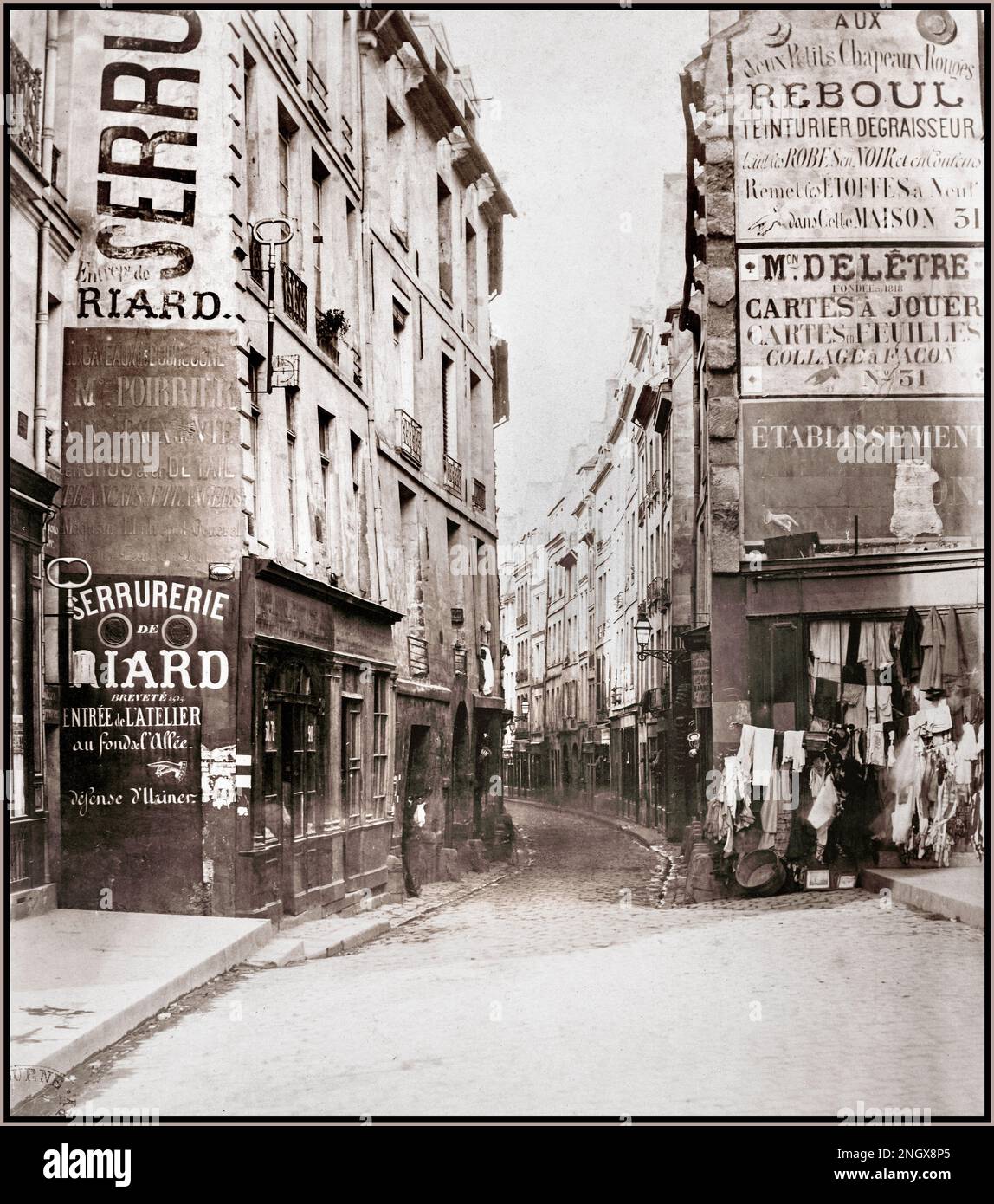 Vintage 1800er Paris Rue de Bievre (du Bould. [D. h. Boulevard] St. Germain) Eingang der engen gewundenen Straße, Bekleidungsgeschäft mit Waren auf dem Weg rechts. Rue de Bièvre, Paris, Frankreich. Datum: Ca. 1853 – 70 Albumsilberdruck des Fotografen Charles Marville Stockfoto