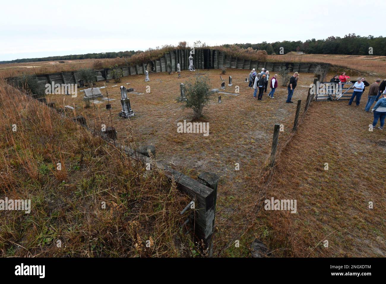 Besucher der Herbstfriedhof-Tour besuchen den Rimes Cemetery, 30. November auf Fort Stewart. Der Friedhof befindet sich in der Mitte der Booker Range, Teil des Red Cloud Range Komplexes, geschützt durch einen 15 bis 20 Fuß hohen Berm, der für das Training der militärischen Fahrzeugregion genutzt wird. Neben seiner einzigartigen Lage beherbergt Rimes auch das höchste Monument auf Fort Stewart mit einer Höhe von 11,152 Metern, das Morgan T. Rimes gehört, der von 1856 bis 1914 auf dem Land lebte. Neben Rimes hatten die Teilnehmer die Möglichkeit, Corinth, Little Creek, Letford, Shuman, Warnell, Thomas Hill und Strum Bay Cemeteri Stockfoto