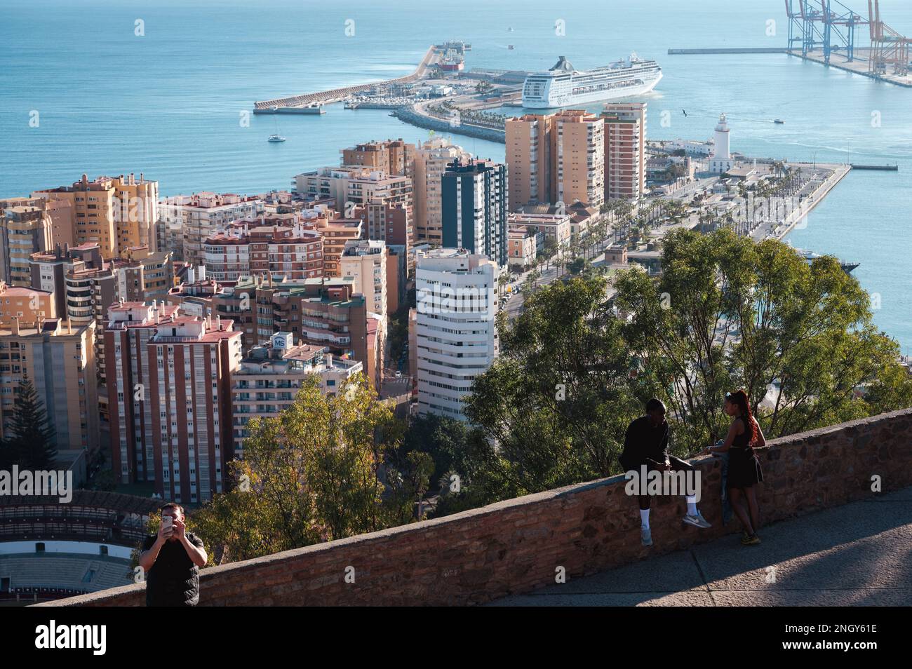 Malaga, Spanien - 15. Januar 2023: Atemberaubender Blick auf Malagas Stadtbild von den Mauern von Castillo de Gibralfaro. Ein paar stehen im Vordergrund, Stockfoto