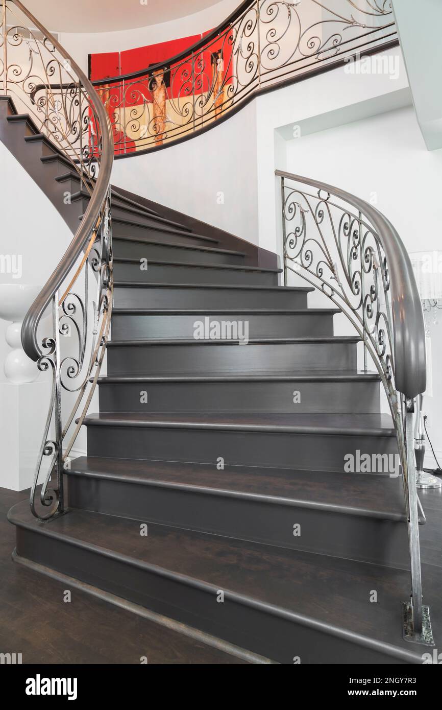 Nach einer spiralförmigen Holztreppe mit schmiedeeisernen Balustern auf den oberen Flur im luxuriösen Haus zu schauen. Stockfoto