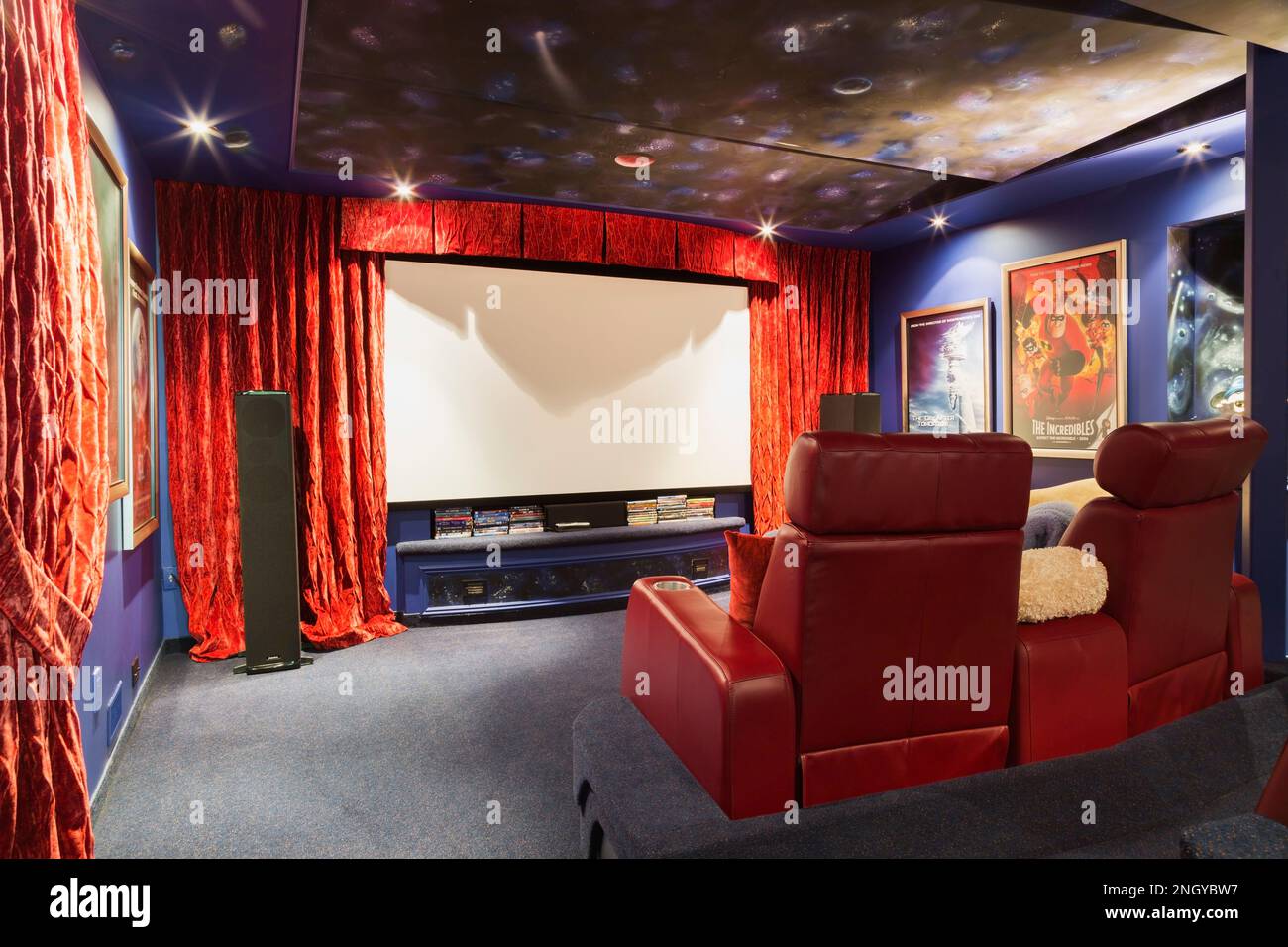 Heimkino mit roten Ledersitzen im Keller im luxuriösen Haus. Stockfoto