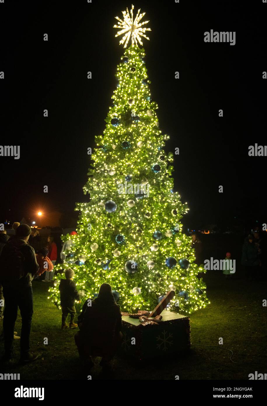 Mitglieder der Gemeinschaft am Luftwaffenstützpunkt Wright-Patterson, Ohio, versammeln sich nach der jährlichen Beleuchtungszeremonie am 1. Dezember 2022 um den Weihnachtsbaum des Stützpunkts auf dem Golfplatz Prairie Trace. Rentierstreicheln, heiße Schokolade und eine Chance für Fotos mit dem Weihnachtsmann waren für Wright-Patt Familien auf der Veranstaltung verfügbar. Stockfoto