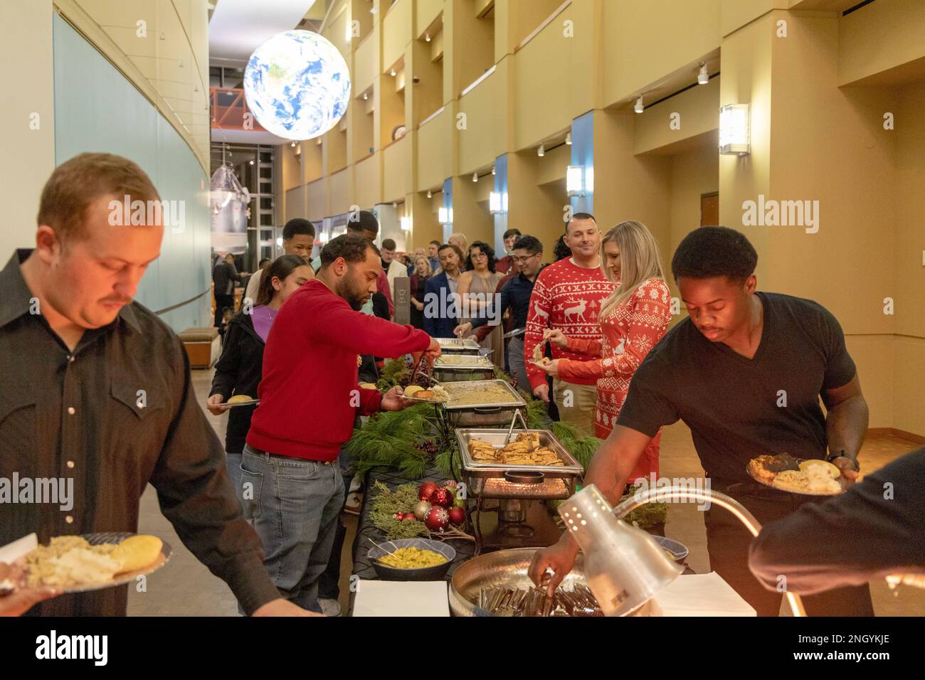 221201-N-MR862-131 OKLAHOMA CITY, OKLAHOMA (01. Dez. 2022) Strategic Communications Wing (SCW) 1 Seeleute, Zivilisten und Familien nehmen am Buffet Teil, das vom Personal des Oklahoma History Center auf der 2022. Jahresfeierparty am 01 2022. Dez. angeboten wird. SCW-1 ist ein Mieterkommando am Luftwaffenstützpunkt Tinker, der die nationale Sicherheit durch Abschreckung gegen gegensätzliche nukleare Ambitionen sicherstellt. Stockfoto