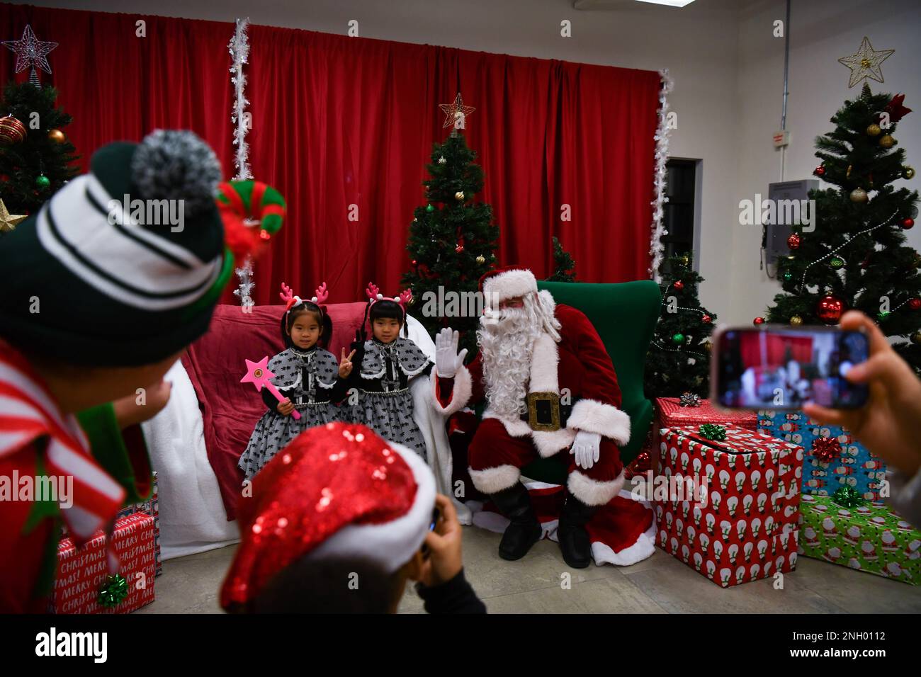 Familien posieren für Fotos mit dem Weihnachtsmann während der USAG Humphreys Holiday Tree Lighting Ceremony am Downtown Plaza, Camp Humphreys, Südkorea, 02. Dezember 2022. Die Veranstaltung zur Baumbeleuchtung findet jährlich statt, um Familien während der Feiertage zusammenzubringen. Stockfoto