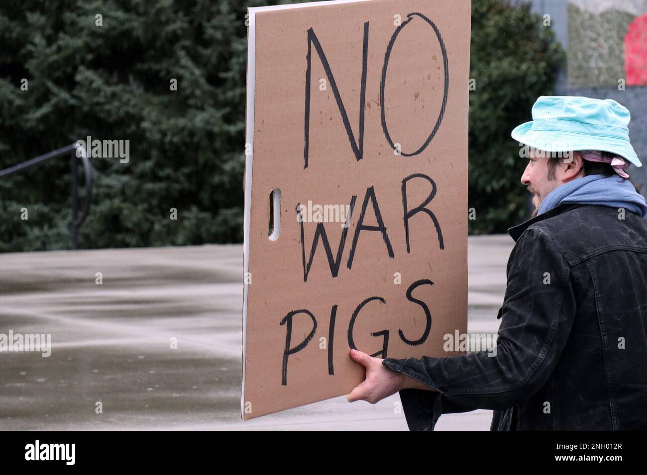 Seattle, Usa. 19. Februar 2023. Ein Mann hält ein Plakat während einer Demonstration gegen die US-Außenpolitik in Seattle. Mehrere Dutzend Demonstranten haben sich gegen kaltes und regnerisches Wetter gewehrt, um sich in einer Vielzahl von Fragen gegen die Opposition auszusprechen, darunter die Unterstützung der USA für die Ukraine und die Inhaftierung des Wikileaks-Gründers Julian Assange. Der Protest fand im Seattle Center statt, einem öffentlichen Park in Seattle, und war Teil einer landesweiten Demonstrationsreihe namens Zorn gegen die Kriegsmaschine. Kredit: SOPA Images Limited/Alamy Live News Stockfoto