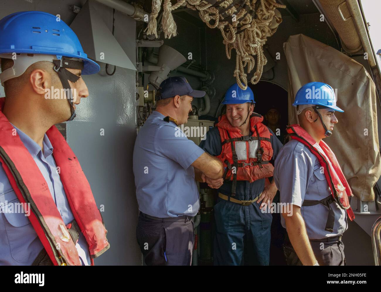 221202-N-EB711-1005 ARABISCHER GOLF (2. Dez. 2022) Ein Matrose, der der Guided-Missile Destroyer USS die Sullivans (DDG 68) zugeteilt wurde, spricht mit einem Mitglied der türkischen Marine an Bord der Corvette TCG Burgazada (F-513) im Arabischen Golf am 2. Dez., was die starke Marinepartnerschaft zwischen den USA und der Türkei widerspiegelt. Stockfoto