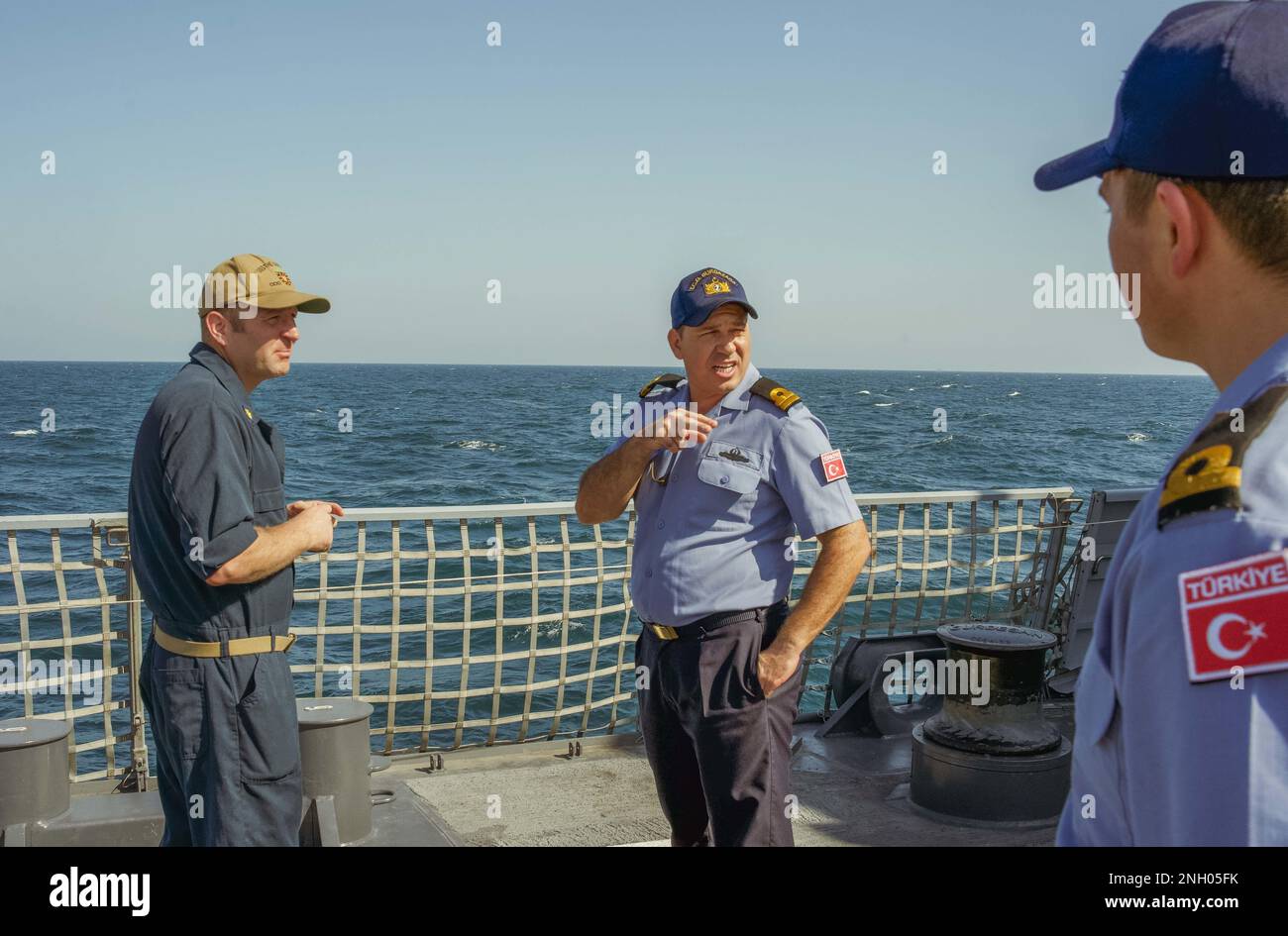 221202-N-EB711-1004 SEELEUTE aus DEM ARABISCHEN GOLF (2. Dez. 2022), die der Zerstörerin USS die Sullivans (DDG 68) zugeteilt sind, sprechen mit einem Mitglied der türkischen Marine an Bord der Corvette TCG Burgazada (F-513) im Arabischen Golf, Dez. 2, worin die starke Marinepartnerschaft zwischen den USA und der Türkei zum Ausdruck kommt. Stockfoto
