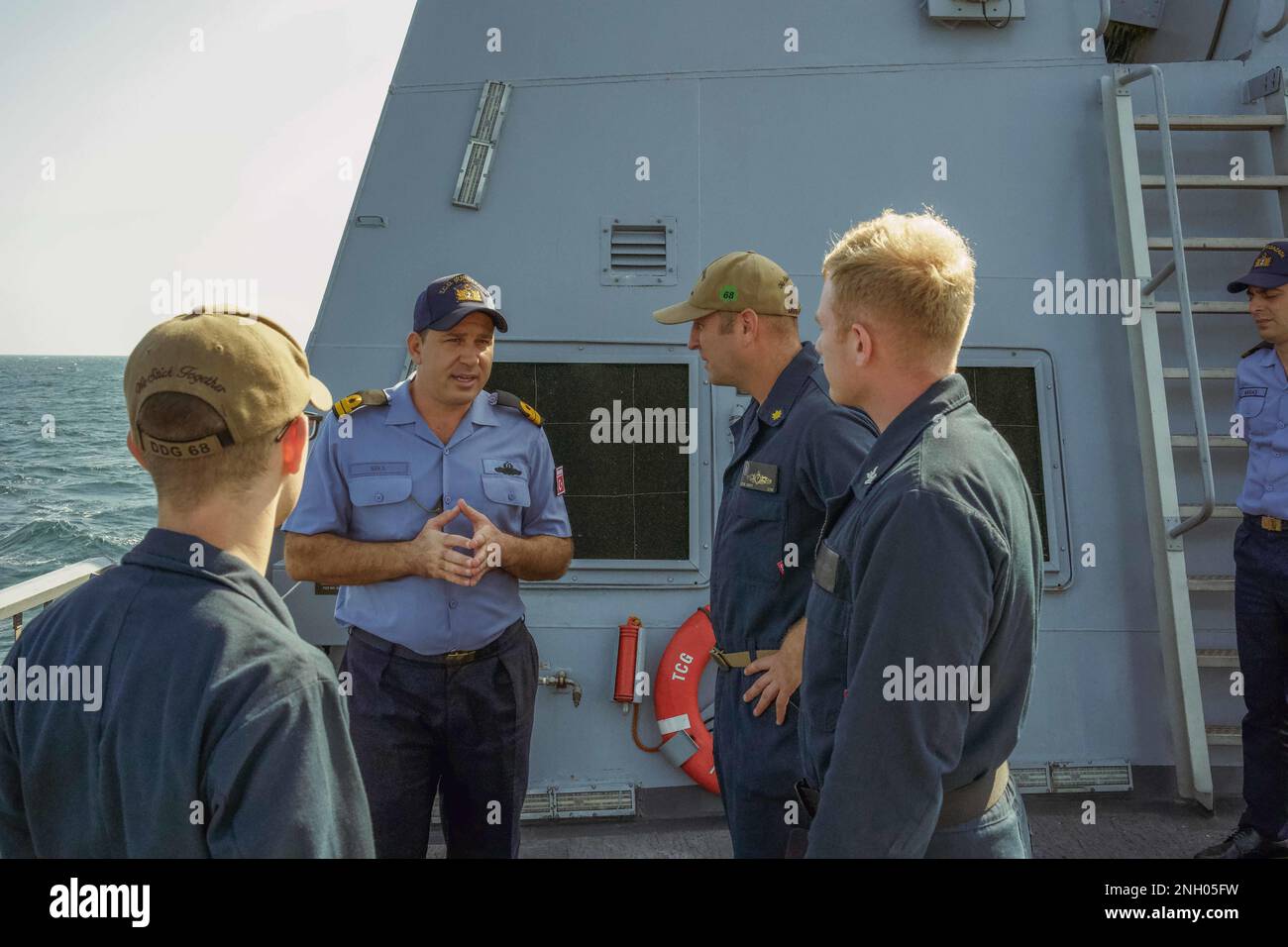 221202-N-EB711-1003 SEELEUTE am ARABISCHEN GOLF (2. Dezember 2022), die der Zerstörerin USS der Sullivans (DDG 68) zugeteilt sind, sprechen mit einem Mitglied der türkischen Marine an Bord der Corvette TCG Burgazada (F-513) im Arabischen Golf, Dezember 2, was die starke Marinepartnerschaft zwischen den USA und der Türkei widerspiegelt. Stockfoto