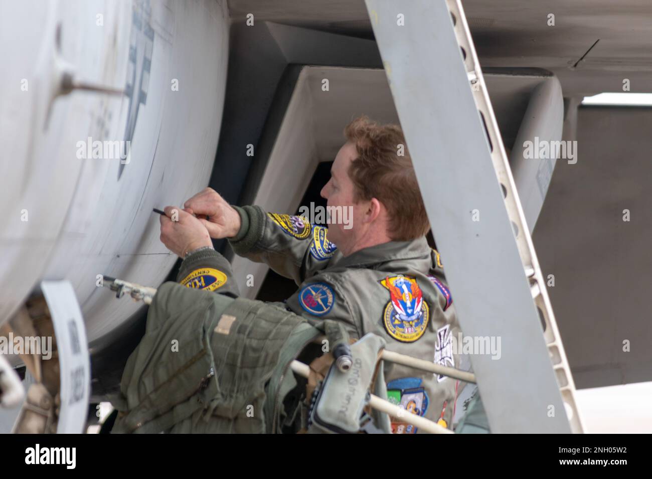 221202-N-MR862-076 TINKER AFB, OKLAV. (02. Dezember 2022) Lt. Cmdr. Jack Keilty, dem Strike Fighter Squadron (VFA) 211 zugeteilt, führt Flugsicherheitsprüfungen auf der Haut eines F/A-18E Super Hornet in der Fleet Air Reconnaissance (VQ) 3 Flightline Dez. 02 2022 durch. Strategic Communications Wing (SCW) 1 ist ein Mieterkommando am Luftwaffenstützpunkt Tinker, der die nationale Sicherheit durch die Abschreckung gegensätzlicher nuklearer Ambitionen gewährleistet. Stockfoto