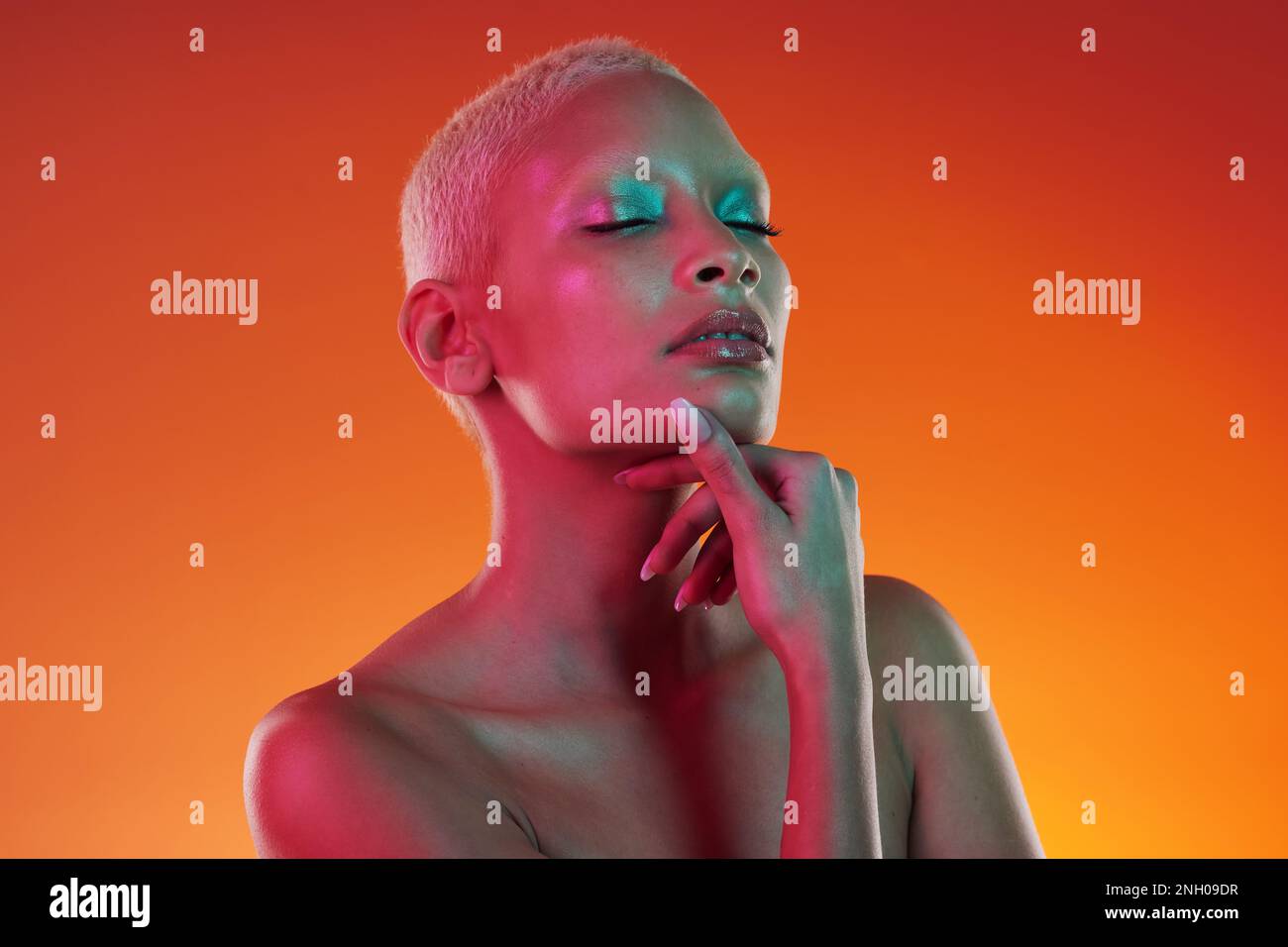 Hautpflege, Schönheit und Augen geschlossen, Frau mit Neon-Make-up und Licht für kreative Werbung auf orangefarbenem Hintergrund. Cyberpunk, Kunst und Modell isoliert Stockfoto