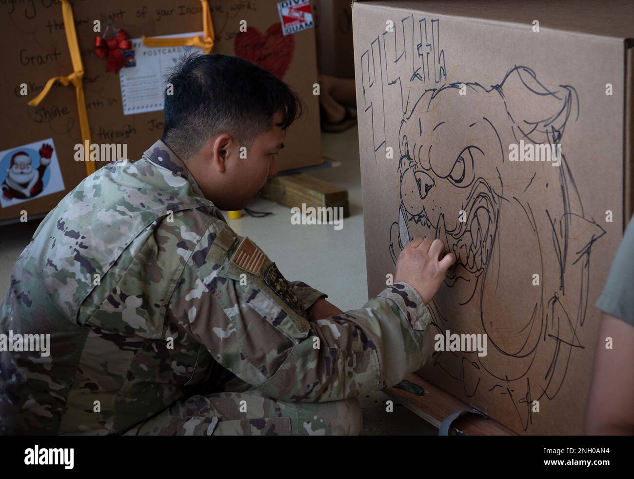 Ein Airman vom 44. Aerial Port Squadron dekoriert während der Operation Christmas Drop 2022 Bundle Build auf dem Luftwaffenstützpunkt Andersen, Guam, 3. Dezember 2022, eine Bündelbox. OCD ist der Abgang der am längsten laufenden humanitären Hilfsmission der Verteidigung von Andersen AFB. Seit 1952 dekorieren, spenden und liefern Airmen jedes Jahr Kisten voller Güter an Bewohner abgelegener Inseln im Pazifik. Stockfoto