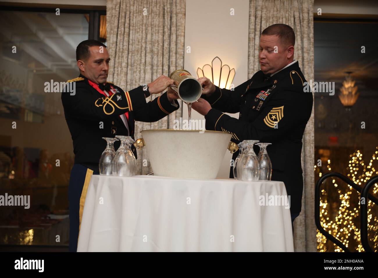 Das 31. Air Defense Artillery Brigade Kommando Team trägt eine Ladung für den zeremoniellen Grog während des Saint Barbara's Social am 3. Dezember im Plaza Hotel in El Paso, Texas. Grog-Zeremonien sind eine Militärball-Tradition und beinhalten normalerweise, dass eine beliebige Anzahl von Spirituosen oder ungewöhnlichen Substanzen in eine große Punchschüssel eingebracht und zum Zweck von Toast gemischt wird. Stockfoto