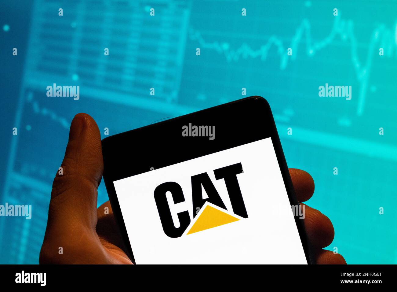 China. 15. Februar 2023. In dieser Fotoabbildung wird das Caterpillar (CAT)-Logo des amerikanischen Baumaschinenherstellers auf einem Smartphone mit einem Diagramm des Börsenindex im Hintergrund angezeigt. (Foto: Budrul Chukrut/SOPA Images/Sipa USA) Guthaben: SIPA USA/Alamy Live News Stockfoto