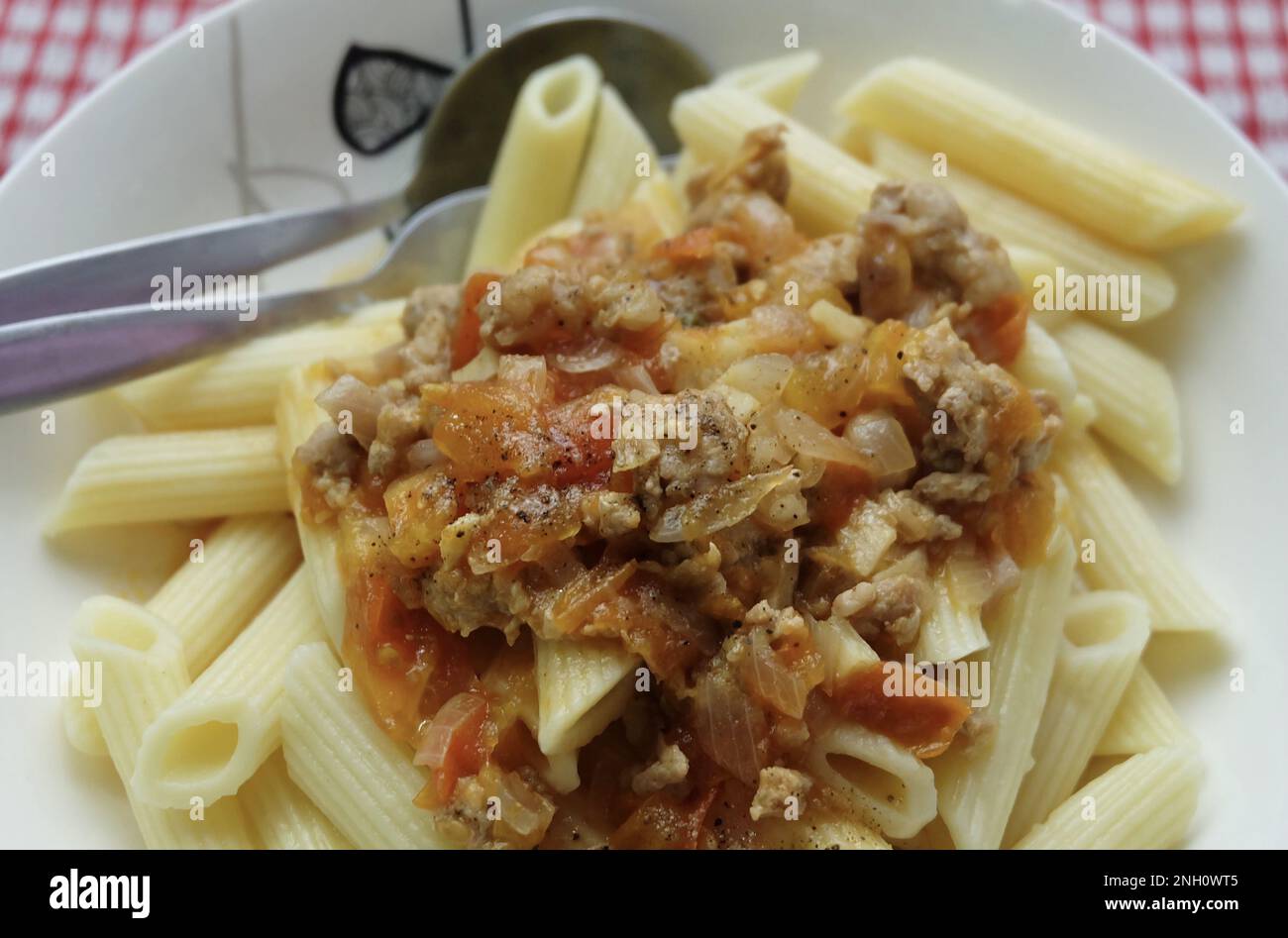 Essen und Küche, Penne Pasta mit einer herzhaften Tomatensoße, garniert mit frischen Kräutern. Stockfoto