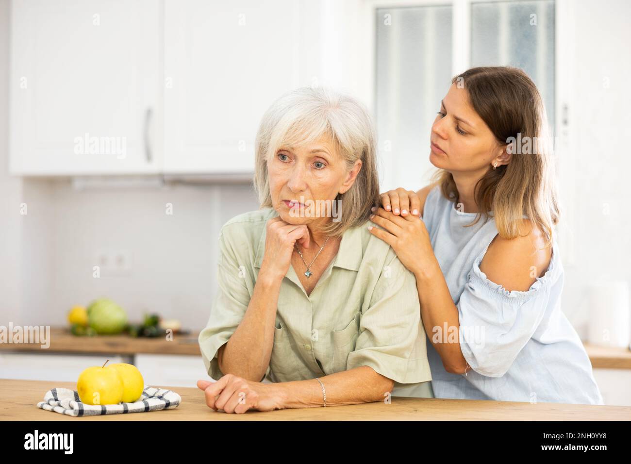 Eine Frau tröstet ihre depressive ältere Mutter Stockfoto