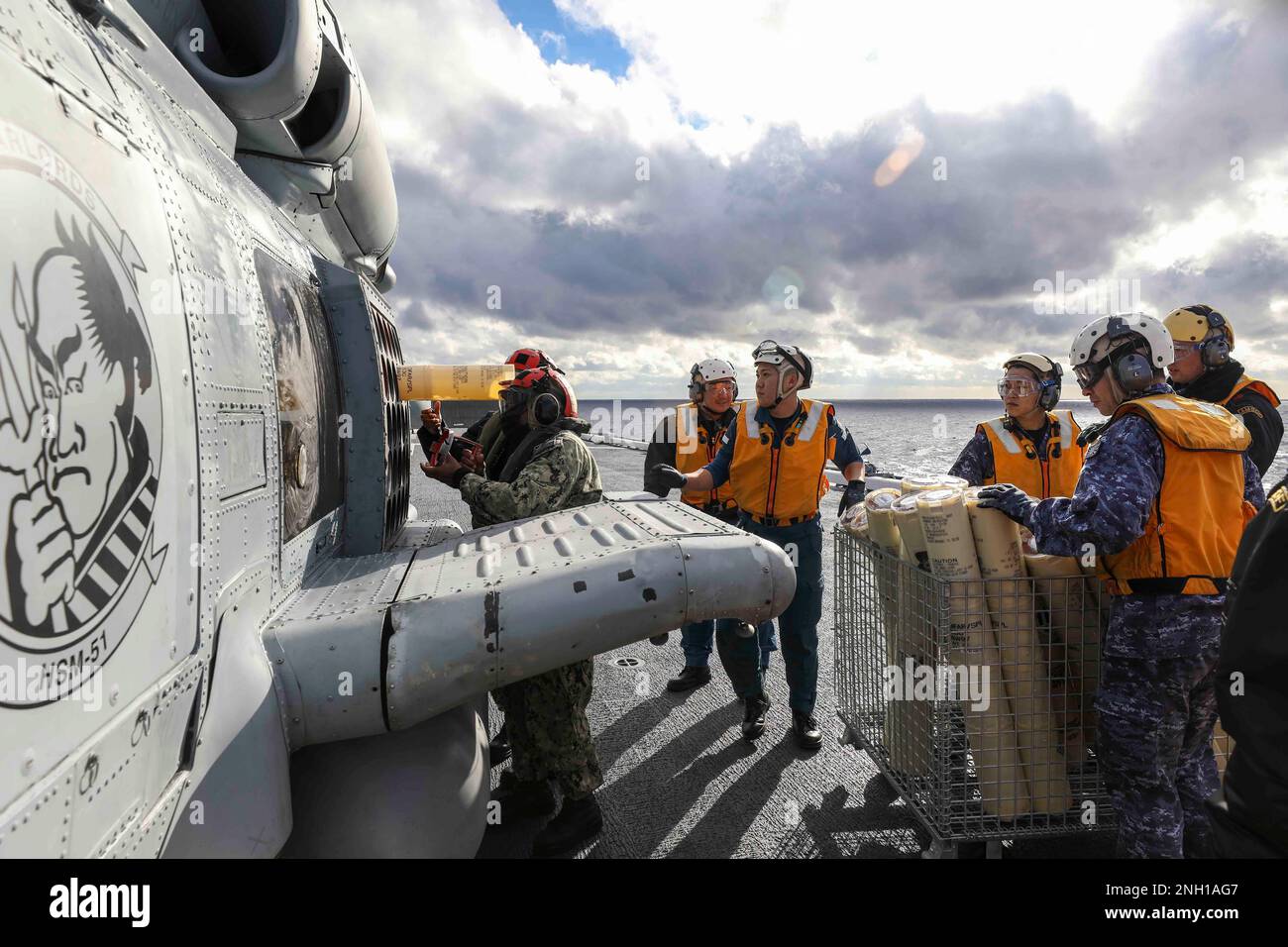 221206-N-FO714-1047 PHILIPPINE SEA (6. Dez. 2022) Aviation Ordnanceman 2. Class Elouise Ellis, Aviation Ordnanceman Airman Tymira Holland and Japan Maritime Self-Defense Force (JMSDF) Seeleute laden Sonobujen in einen MH-60R Sea Hawk Helikopter, der den „Warlords“ des Helicopter Maritime Self-Strike-Squadron Jzumo 51 zugewiesen ist (DDH 183) während einer bi-lateralen Anti-U-Boot-Kriegsführung (ASW) am 6. Dezember. Die USA Die Marine und die JMSDF fliegen und segeln regelmäßig mit anderen Alliierten und Partnern zusammen, um Sicherheit und Stabilität in der gesamten Region zu fördern. Stockfoto