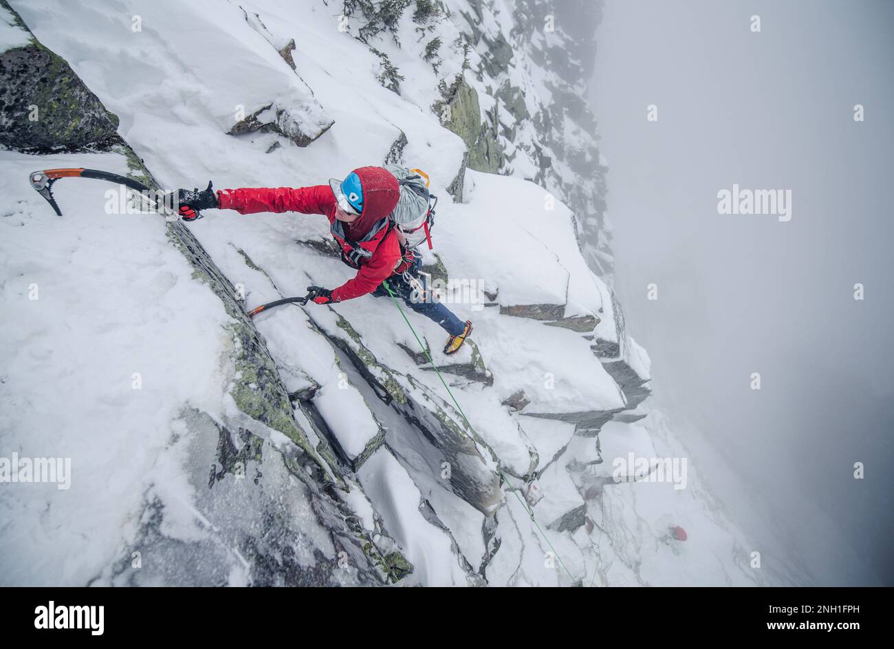 Eiskletterer, die einen steilen Abschnitt von Felsen und Eis besteigen Stockfoto