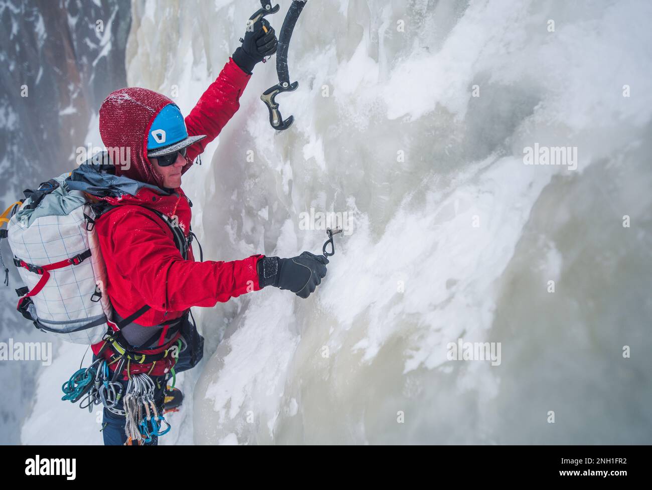 Eiskletterer, der beim Klettern die Eisschraube eindreht Stockfoto