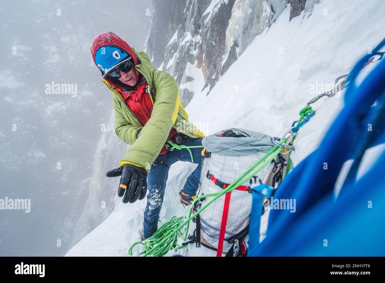 Eiskletterer trägt schwere Jacke während der Klettertour Stockfoto