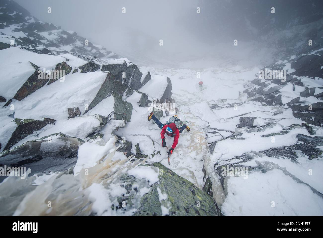 Eiskletterer, die einen steilen Abschnitt von Felsen und Eis besteigen Stockfoto