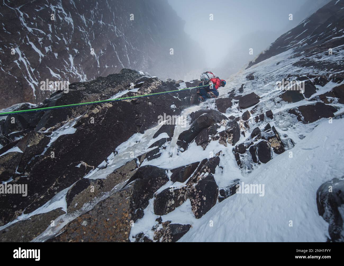 Bergsteiger klettern auf Felsen und Eiswände im Schnee Stockfoto