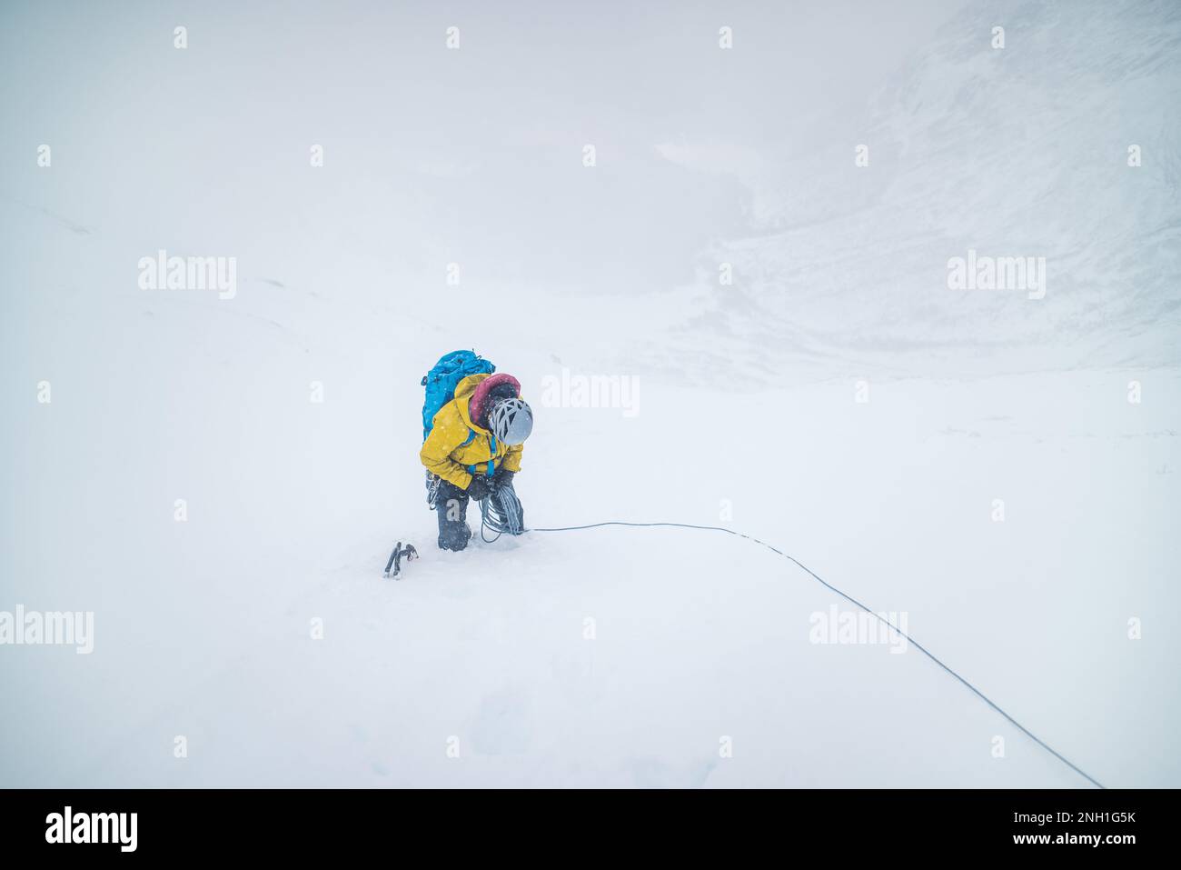 Männliche Bergsteiger klettern bei schneebedeckten Witterungsbedingungen Stockfoto