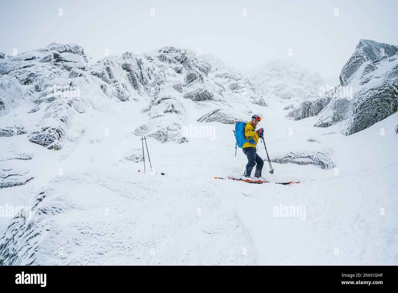 Skifahrer in gelber Jacke macht sich bereit für den Frost Stockfoto