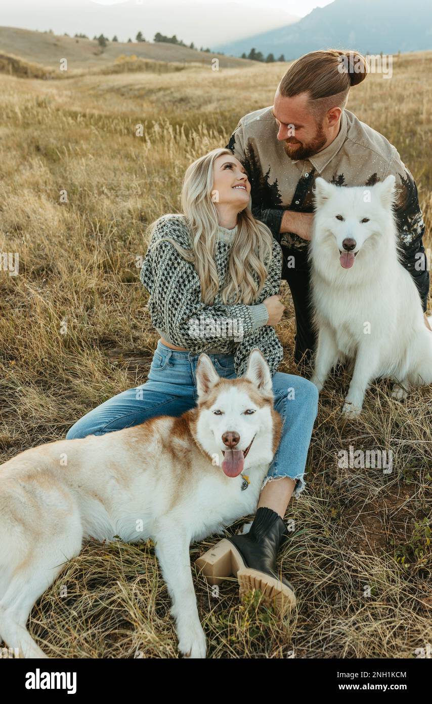 Ein Paar mit Husky-Hunden draußen Stockfoto