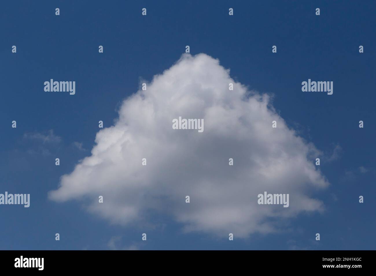 Blick auf eine weiße Wolke, die wie eine Pyramide in einem blauen Himmel aussieht Stockfoto