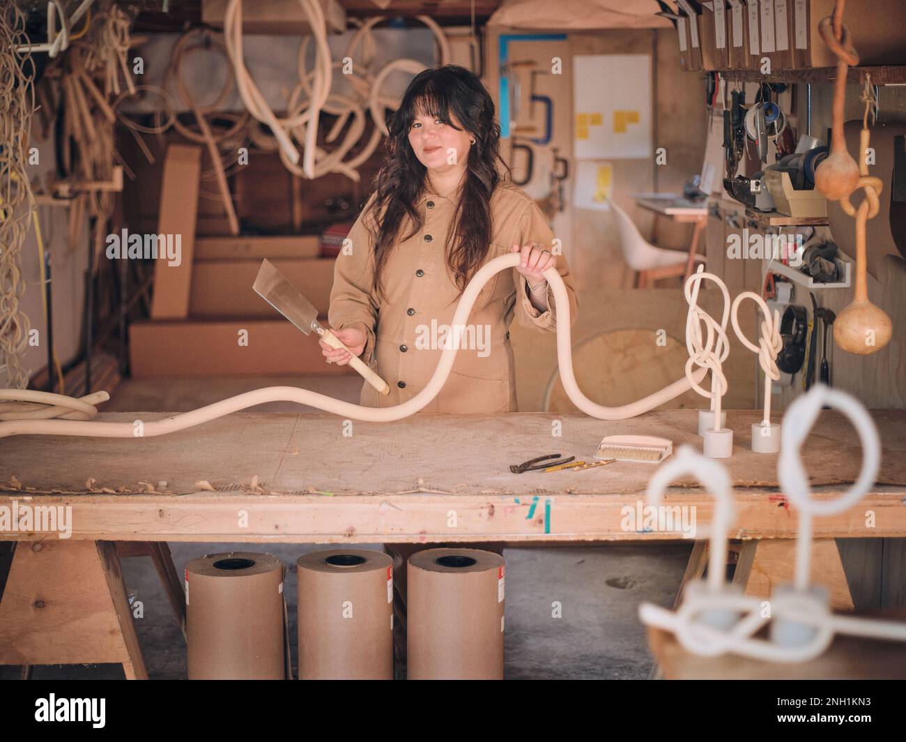 Eine Künstlerin in ihrem Studio arbeitet mit einer ihrer Holzskulpturen Stockfoto
