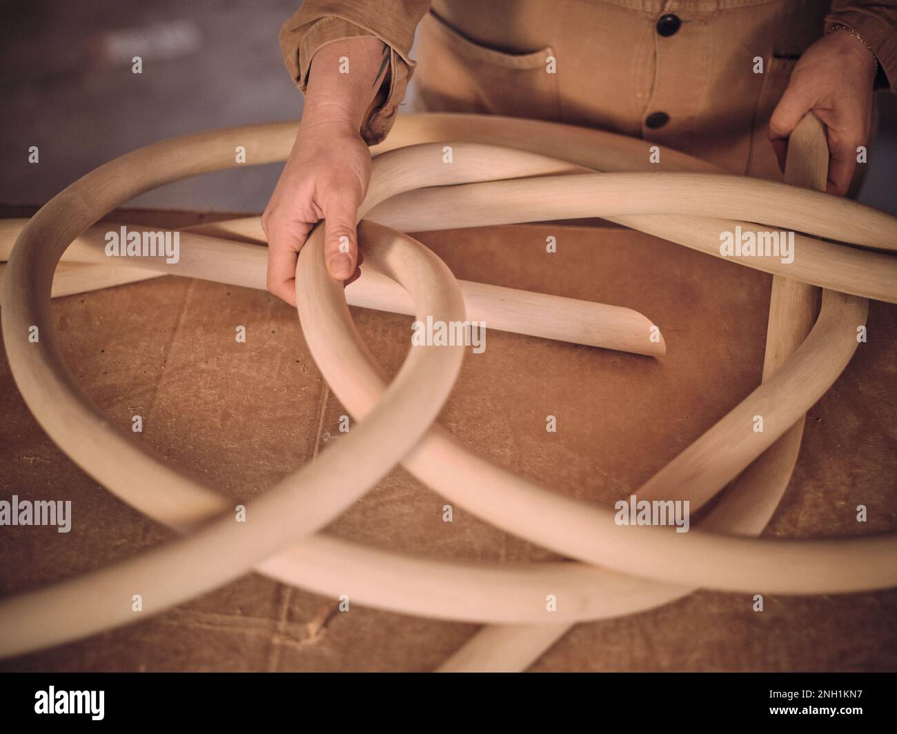 Eine Künstlerin in ihrem Studio arbeitet mit einer ihrer Holzskulpturen Stockfoto