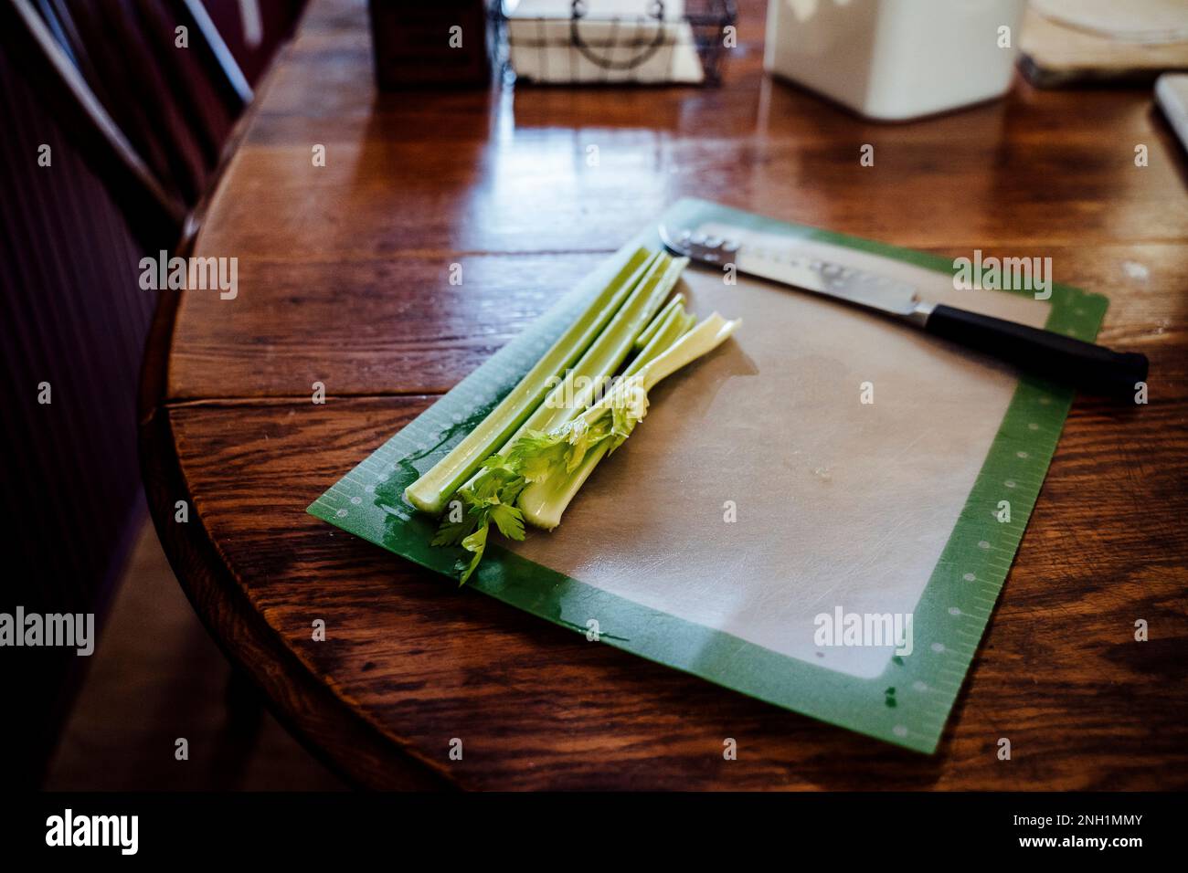 Ein Haufen Sellerie, die auf dem Holzküchentisch auf dem Schneidebrett stapelt Stockfoto