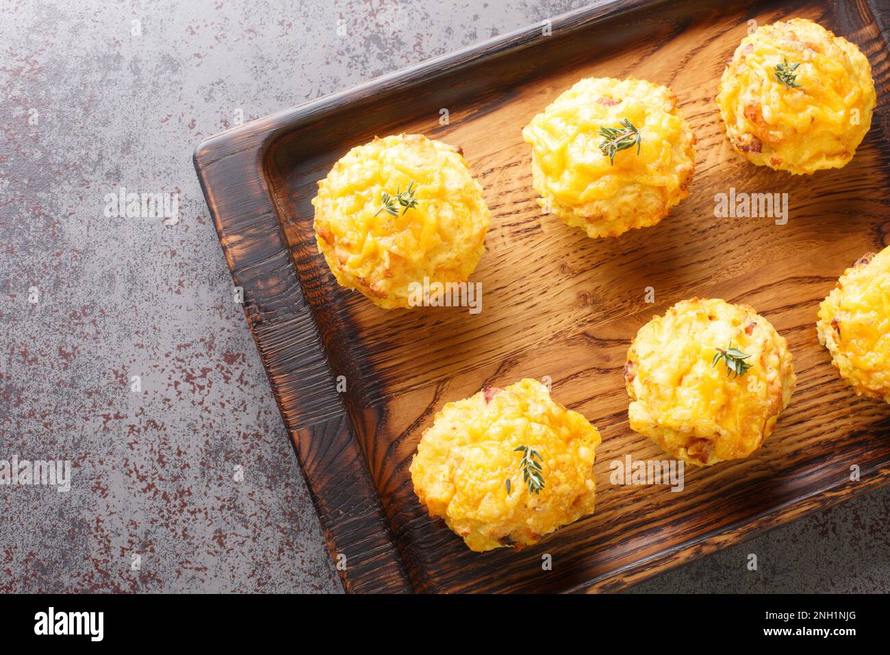 Vorspeise Kartoffel Muffins mit Speck und Käse auf Holzbrett, dicht auf dem Tisch. Horizontale Draufsicht von oben Stockfoto