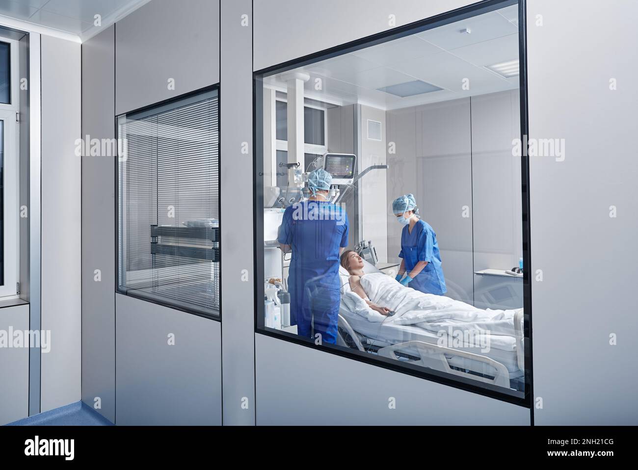 Zwei Ärzte, die eine Patientin in der Krankenhausabteilung betreuen. INTENSIVSTATION Stockfoto