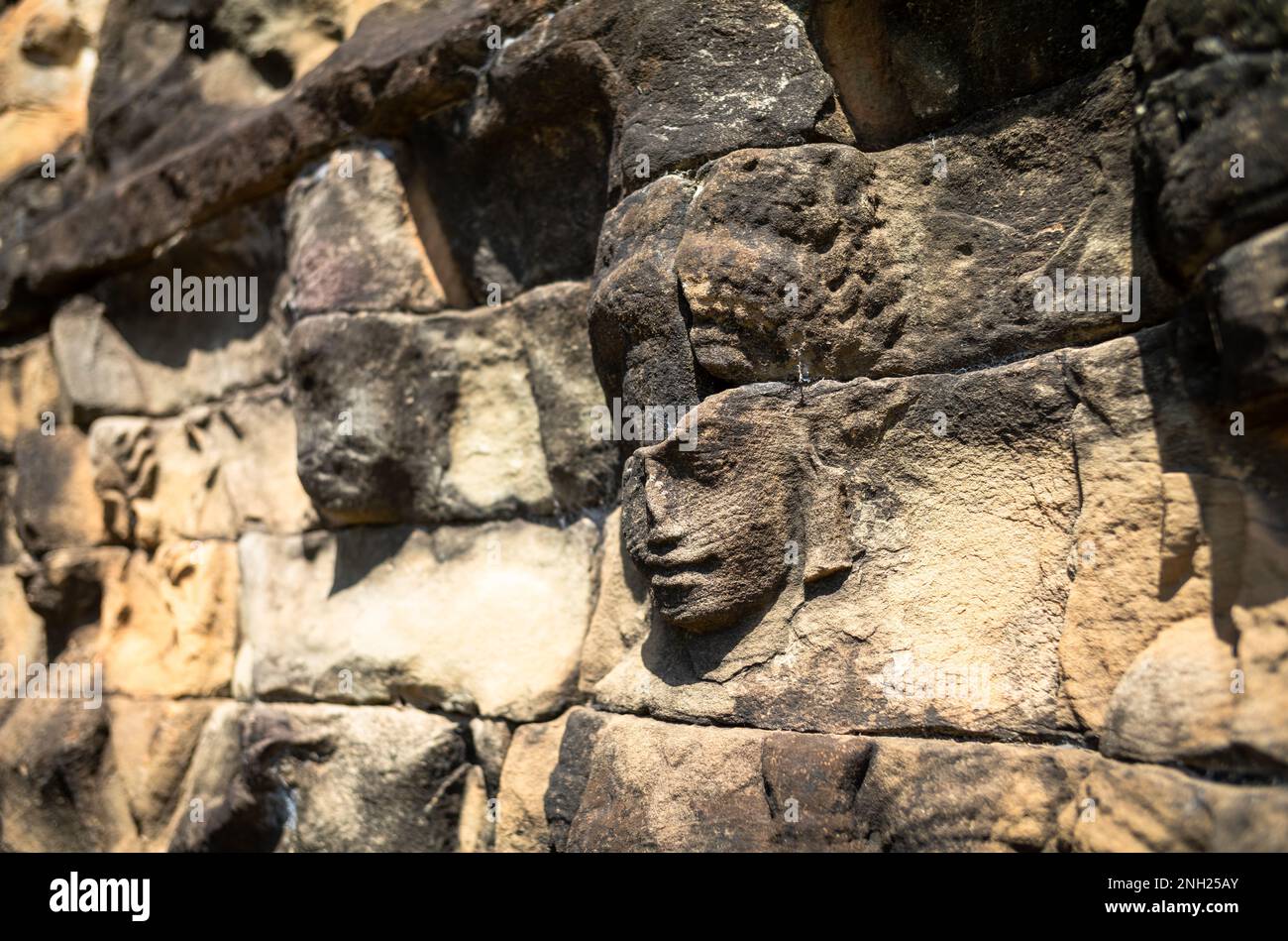 Alte und verwitterte Gesichter in Sandstein auf der Terrasse des Lweper King im Angkor-Komplex in Kambodscha. Stockfoto