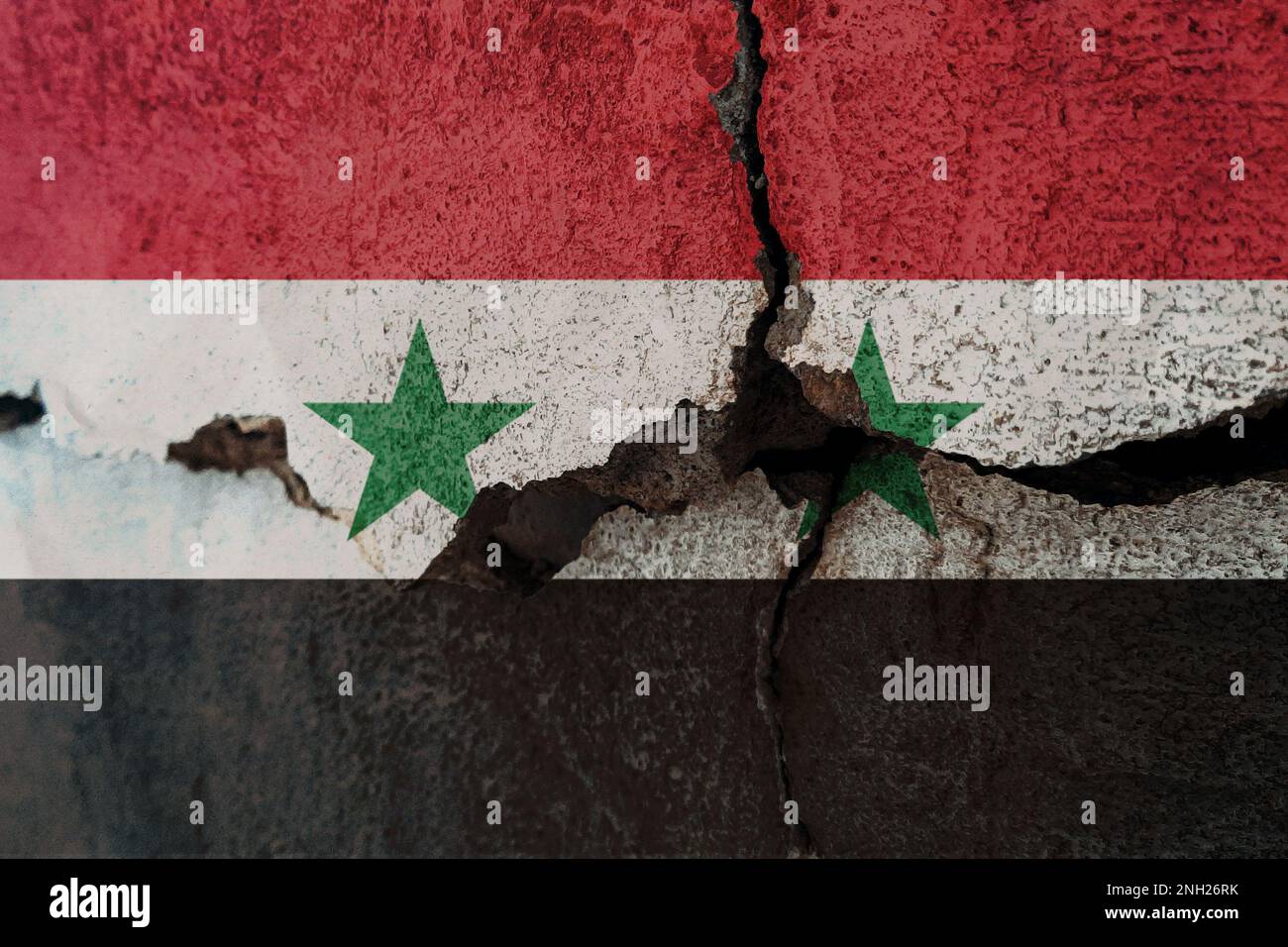 Syrische Flagge an gerissener Wand. Erdbeben- oder Dürrekonzept Stockfoto