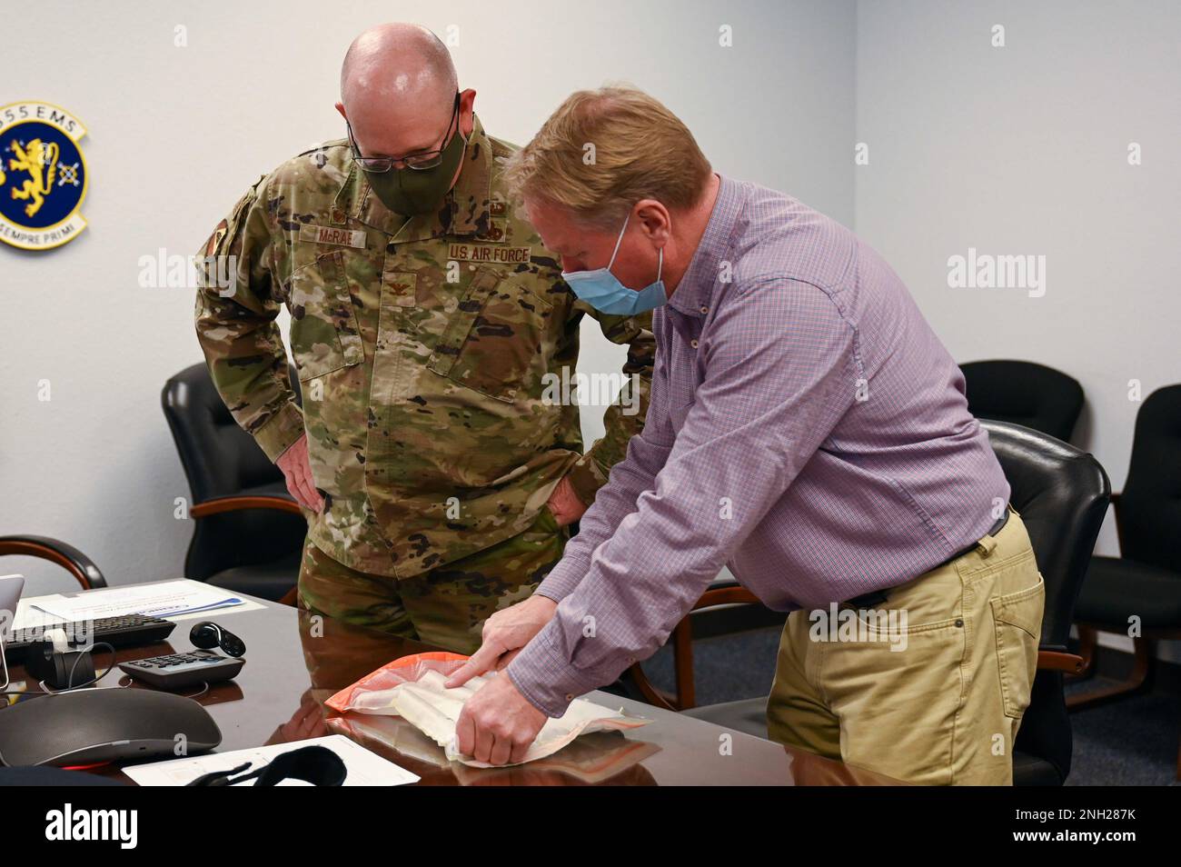 USA Air Force Oberst Clarence McRae, 355. Maintenance Group Commander, sieht Mark Weitz, Vice President of Strategic Development bei Kennon Products, bei einer Machbarkeitsstudie auf dem Luftwaffenstützpunkt Davis-Monthan, Ariz, am 7. Dezember 2022 die innere Funktionsweise eines Prototyps einer Kühlweste. Die Kühlweste verwendet Trockeneis, um Alkohol in einem geschlossenen Pumpensystem zu kühlen, das dann durch das Innere der Weste gepumpt wird, um den Kern des Trägers abzukühlen. Stockfoto