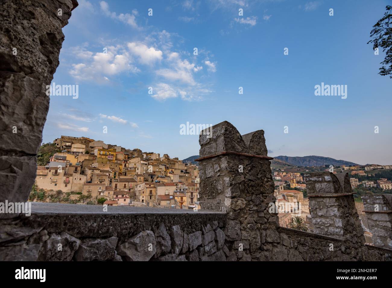 Zinnen verzierte Mauern der Burg Caccamo mit dem Dorf im Hintergrund, Sizilien Stockfoto
